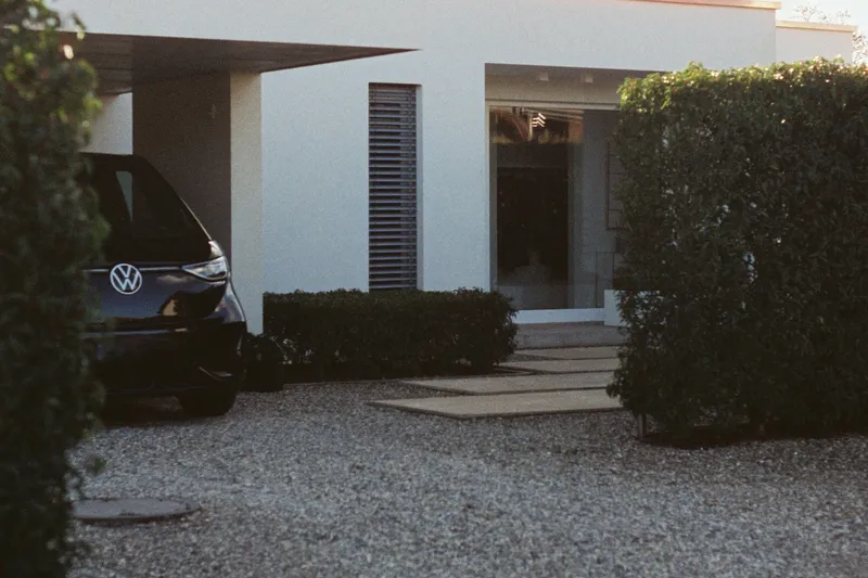 Carport contemporain à toit plat devant une maison, surface de toiture entièrement dégagée