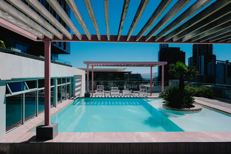 Pergola bioclimatique autoportée installée en îlot au bord d'une piscine